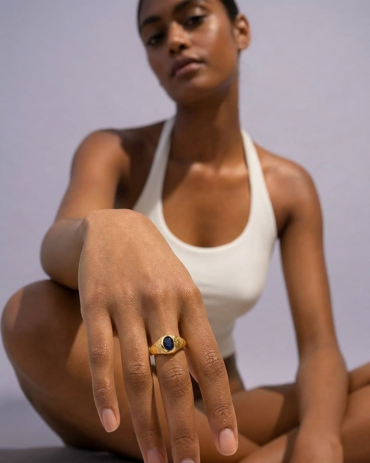 AI-generated jewellery photography. Hand wearing a gold sapphire ring.