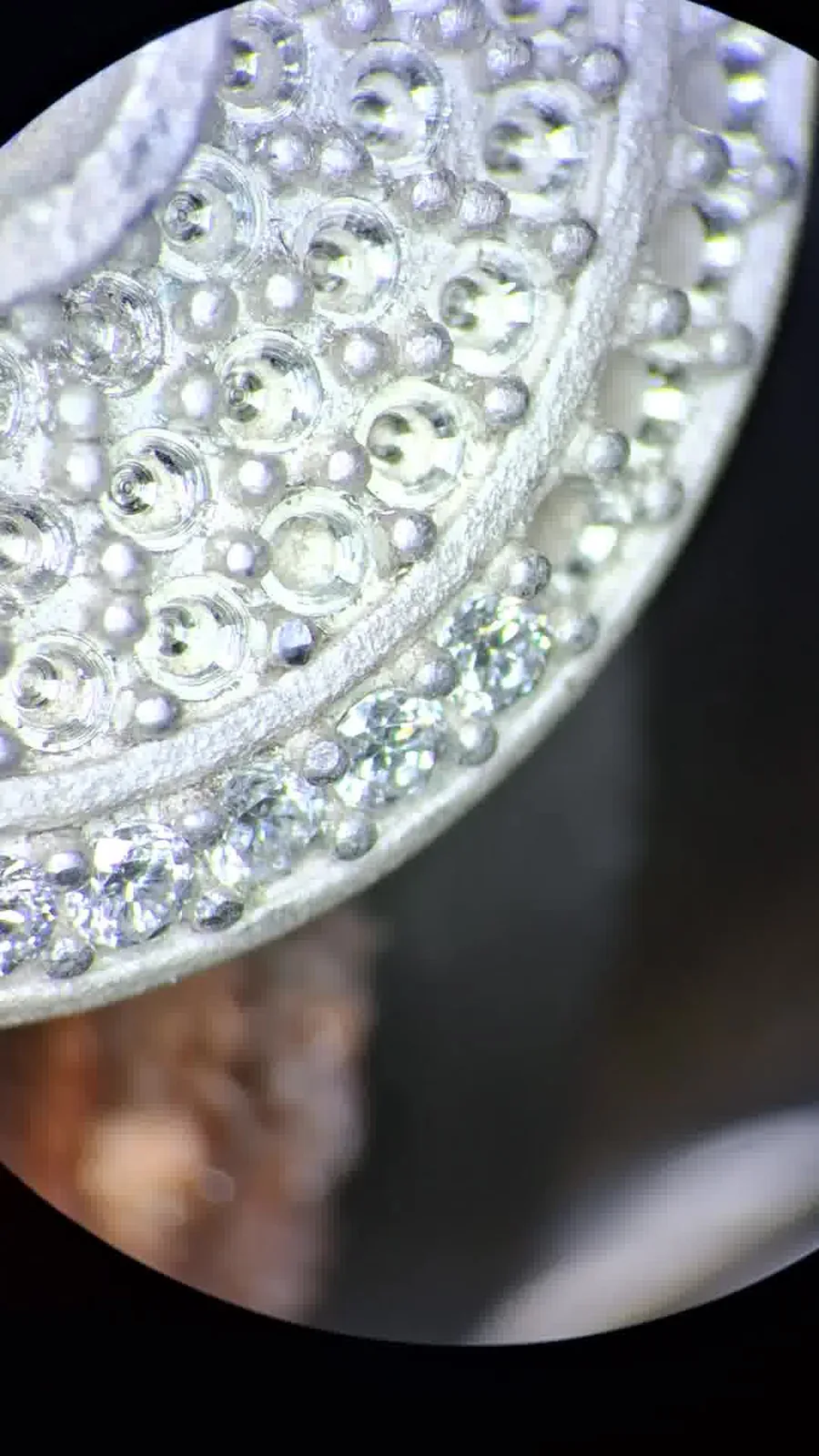 The same disc's pave setting seen through a bench microscope, individual stones and settings sharply resolved